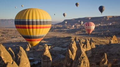 Plane jetzt deinen Türkei Urlaub mit Kindern und genieße ihn beispielsweise in Kappodokien mit einem atemberaubenden Ausblick auf die Landschaft mit vielen Heißluftballons, die typisch für diese Region sind.